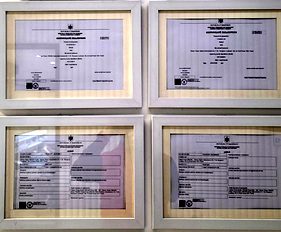 Framed registration certificates on the wall of the Creadent clinic, real photo