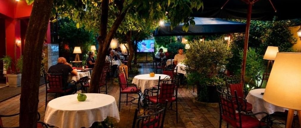 The garden restaurant at Vila 15 in the evening, tables set