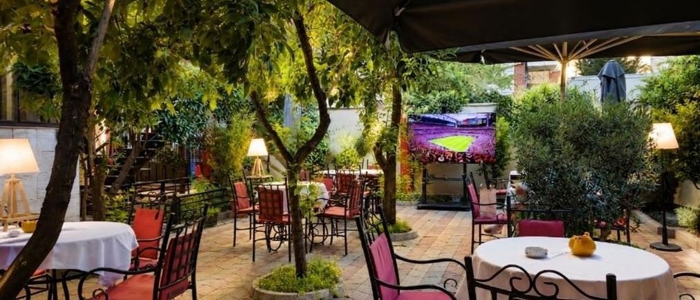 The garden restaurant at Vila 15 by day, under the trees